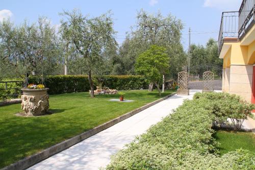 a garden with green grass and a building at Villa Due Leoni - Residence in Brenzone sul Garda