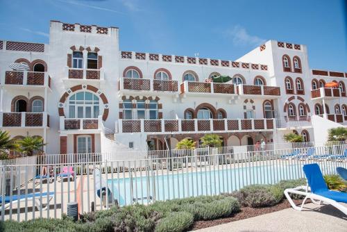 un grand bâtiment blanc avec une piscine dans l'établissement Appartement OCEAN, à La Tranche-sur-Mer