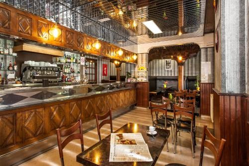 ein Restaurant mit einer Bar mit Tischen und Stühlen in der Unterkunft Hôtel Des Rochers in Marvejols