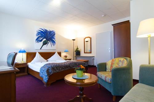 a hotel room with a bed and a couch and a table at Regina in Heidelberg