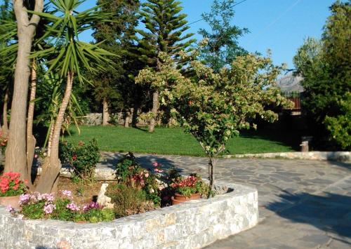 a garden with flowers and plants in a stone planter at Plakias Villas in Lefkogeia