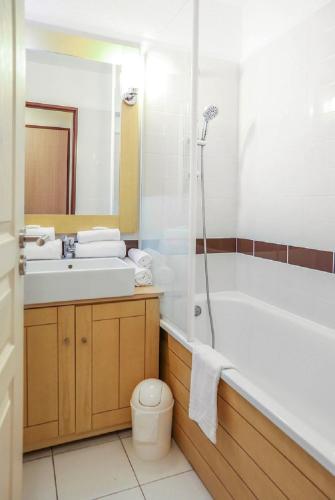 une salle de bain avec une baignoire, un lavabo et des toilettes dans l'établissement Residence Le Beach - maeva Home, à Trouville-sur-Mer