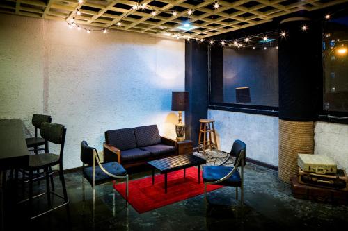 a living room with a couch and a table and chairs at Orchard Street Hotel in New York