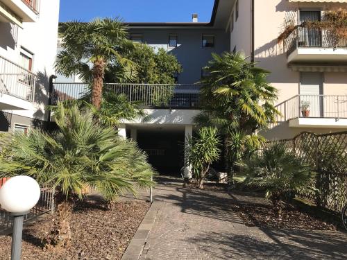 a courtyard with palm trees in front of a building at Casa Chiara in Riva del Garda