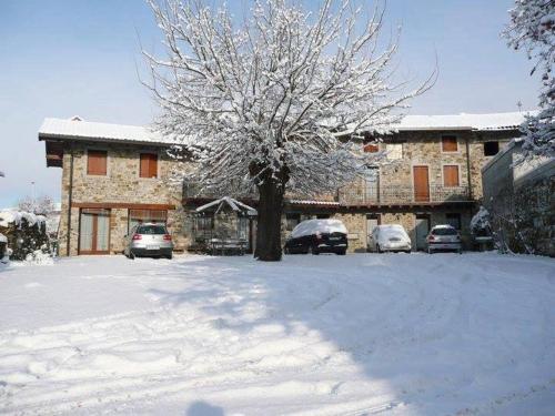 a snow covered yard with cars parked in front of a building at Agriturismo Clochiatti in Povoletto