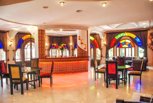 a restaurant with a table and chairs and stained glass windows at Riad Noumidya in Fès