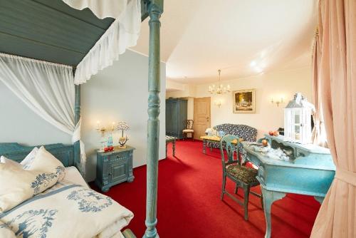 a bedroom with a canopy bed and a bedroom with a desk at Hotel Haus Keuthen in Olsberg