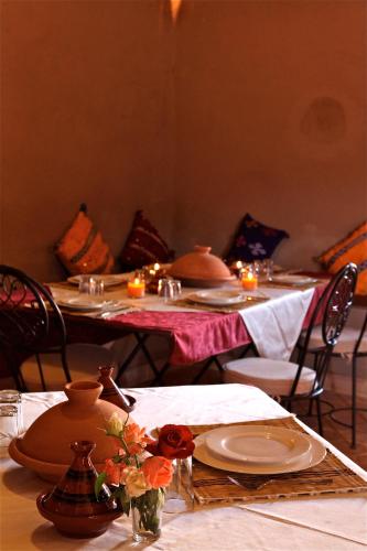 a group of tables with candles and plates on them at Riad Nomad in Foum Mharech