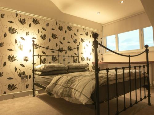 1 dormitorio con 1 cama y papel pintado con motivos florales en Manhattan loft en Margate