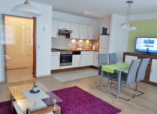 Una cocina y una sala de estar con mesa y sillas. en Harzburger Ferienwohnung, en Bad Harzburg
