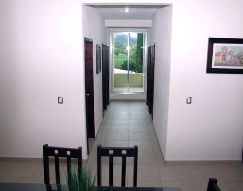 an empty hallway with two chairs and a window at MR Hotel in San Pedro Jácuaro