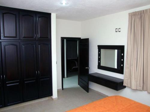 a bedroom with black cabinets and a mirror at MR Hotel in San Pedro Jácuaro