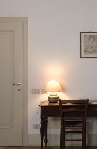 a lamp sitting on a wooden table with a chair at Tenuta Le Sorgive Agriturismo in Solferino