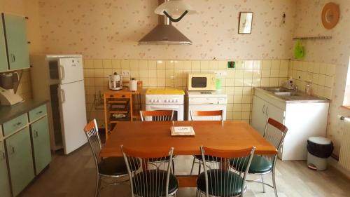 una cocina con mesa de madera y sillas. en Vignobles Frey-Sohler, en Scherwiller