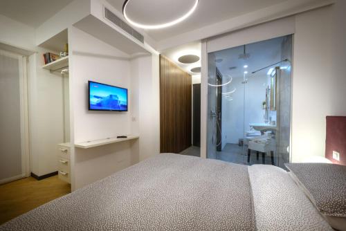 a bedroom with a bed and a bathroom with a shower at Eco Rooms&Breakfast Tirano in Tirano