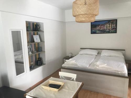 a bedroom with a bed with a mirror and a table at Home Sweet Apartment in Bük