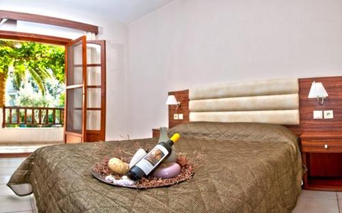 a bed with a tray with wine bottles on it at Villa Panagiota in Toroni