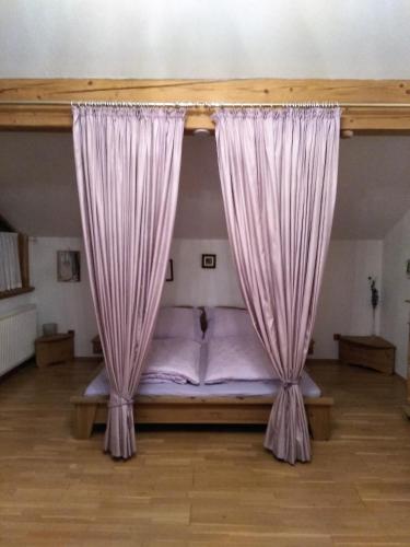 a bed with pink curtains in a room at Ossiachersee Apartments in Steindorf am Ossiacher See