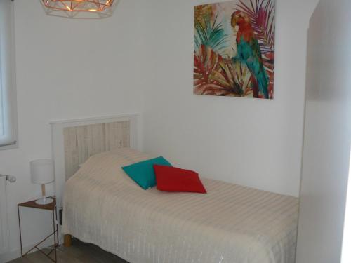 um quarto com uma cama com uma almofada vermelha e azul em Cocooning Villa em Cherbourg en Cotentin