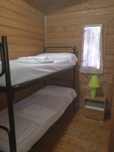 a bedroom with two bunk beds and a window at Campeggio Italia in Marina di Massa
