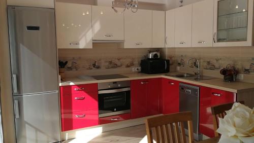 a kitchen with red cabinets and a refrigerator at Piso vacacional, Mijas Pueblo in Mijas