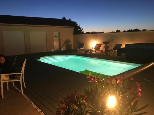 una piscina en un patio trasero por la noche en Chez Jojo & Cassi en Vert-Saint-Denis