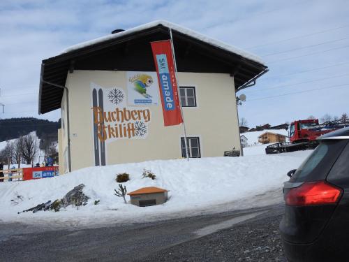 a building with a sign on it in the snow at Bergschlössl in Goldegg