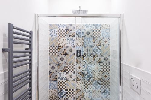 a shower in a bathroom with a tile wall at Sixty One Luxury Room in Rome