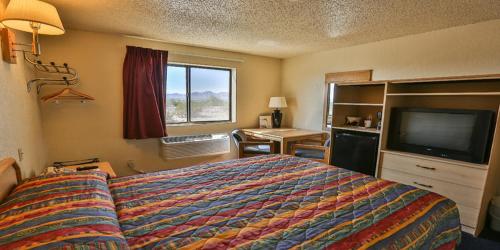 a hotel room with a bed and a flat screen tv at Super 8 by Wyndham Lake Havasu City in Lake Havasu City