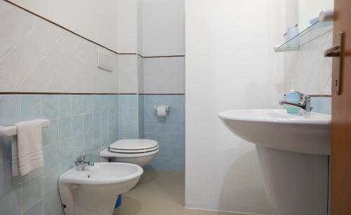 y baño con aseo blanco y lavamanos. en Il Giardinetto, en Alghero
