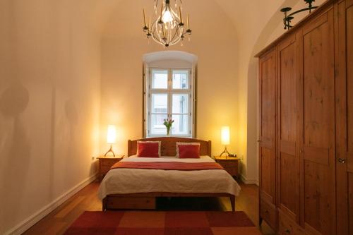 a bedroom with a bed and a window and a chandelier at Design Apartment Eger in Eger