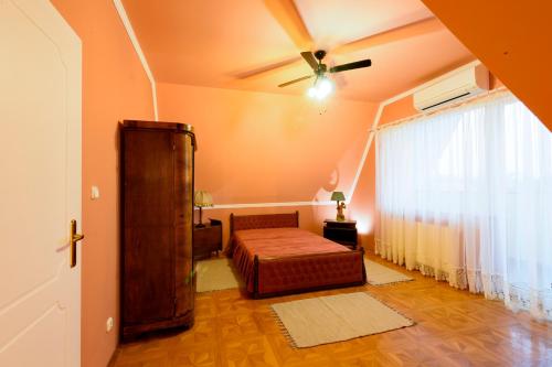 a bedroom with a bed and a ceiling fan at Elite Boutique Villa Örkény in Örkény
