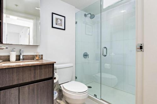 a bathroom with a toilet and a glass shower at 2 Bedroom No 3.Rd Apartment Skytrain in Richmond