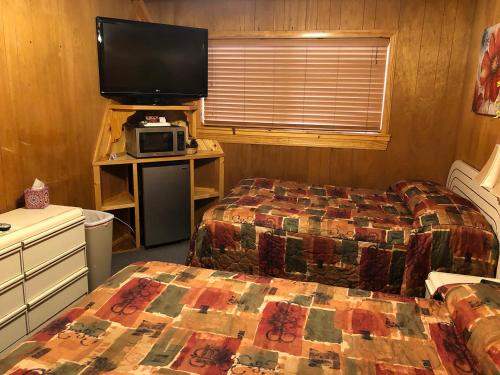 a bedroom with two beds and a flat screen tv at Giant Oaks Lodge in Running Springs