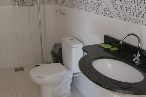 La salle de bains est pourvue de toilettes, d'un lavabo et d'une douche. dans l'établissement Hotel Pousada Recanto do Pai, à Trindade