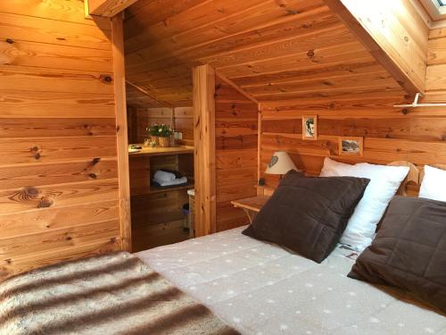 サン・ジェルヴェ・レ・バンにあるChalet La Grande Ourseの木造キャビン内のベッド1台が備わるベッドルーム1室を利用します。