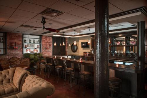 a bar with leather chairs and a bar counter at The Historic Brookstown Inn, Trademark Collection by Wyndham in Winston-Salem