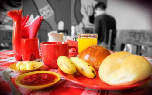 um prato vermelho de comida numa mesa com fruta em Great Partners hostel em Lima