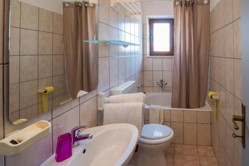 een badkamer met een wastafel, een toilet en een bad bij Apartments Jagoda in Vrbnik