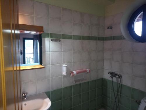 La salle de bains est pourvue d'un lavabo, d'une douche et d'une fenêtre. dans l'établissement Elikonio, à Agia Anna