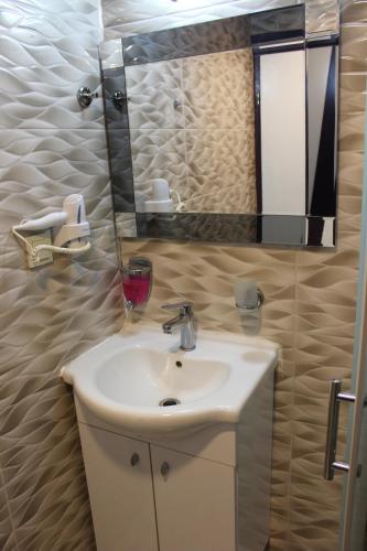 a bathroom with a sink and a mirror at Laleli Hotel Izmir in İzmir