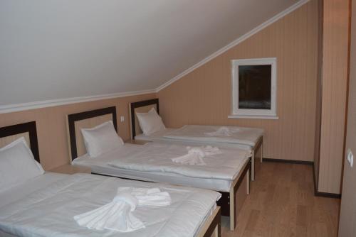 two beds with white sheets in a room at Millennium Rabati in Akhaltsikhe