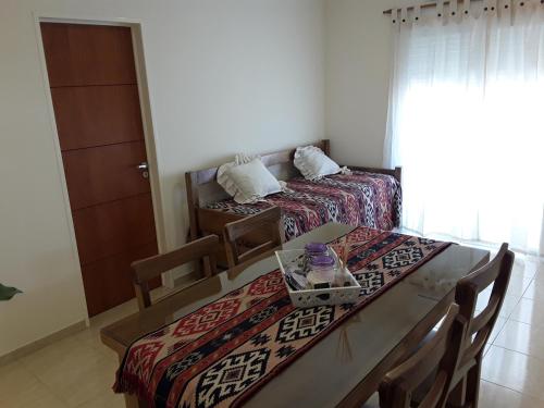 a room with two beds and a table with chairs at Departamentos Solares - Bravard in Bahía Blanca