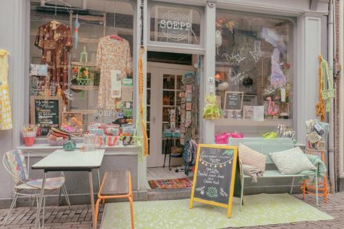a store front with a table and chairs and a chalkboard at SOEPP hotel & restaurant in Alkmaar