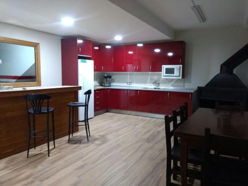 a kitchen with red cabinets and a table and chairs at Escapada Delux in Ossa de Montiel