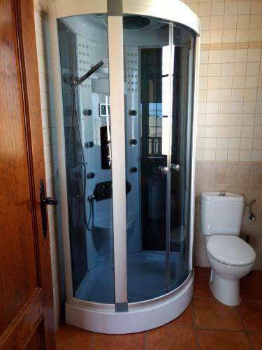 a bathroom with a glass shower with a toilet at Escapada Delux in Ossa de Montiel