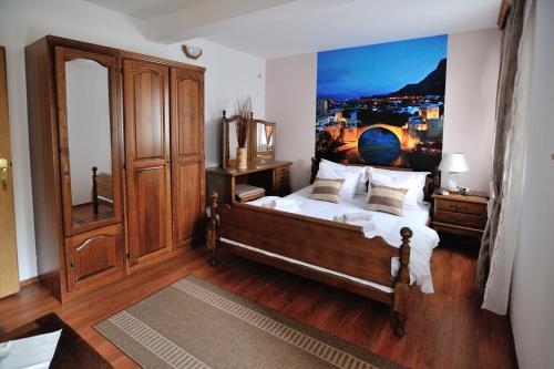 a bedroom with a bed with a painting on the wall at Motel Edem in Mostar