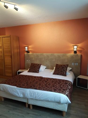 - une chambre avec un grand lit et 2 oreillers dans l'établissement Oyonnax Bellignat Appart Hotel, à Bellignat