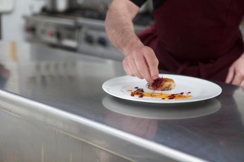 a person holding a plate of food on a counter at URH Excelsior in Lloret de Mar