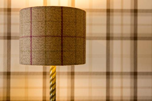 a lamp in a room with a wall at The Tongue Hotel in Tongue